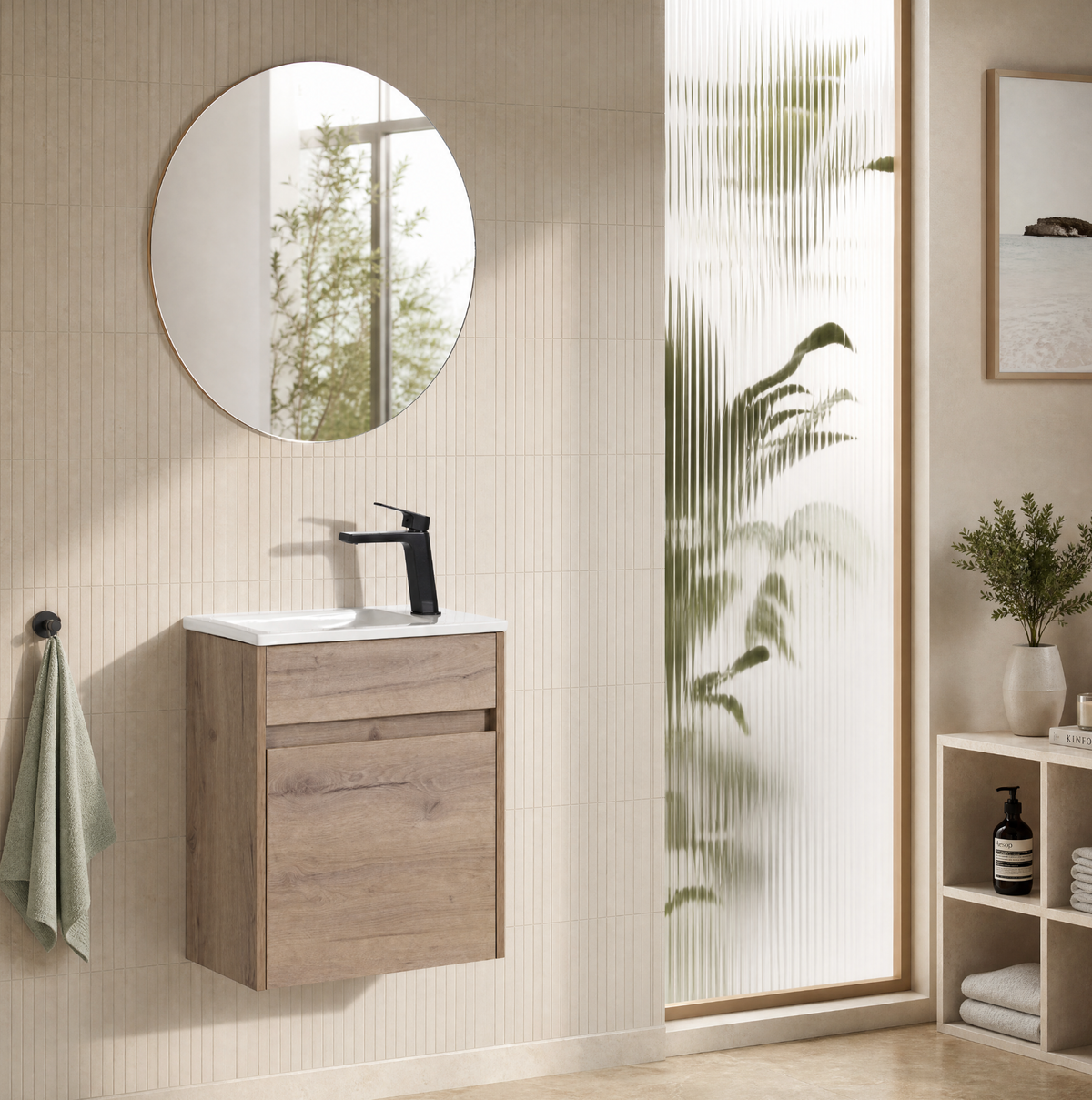 A modern wall-mounted bathroom vanity with a light oak wood cabinet, white sink basin, black faucet, and a round wall mirror, shown in a styled bathroom setting with beige tiles, a frosted glass door, and indoor plants.