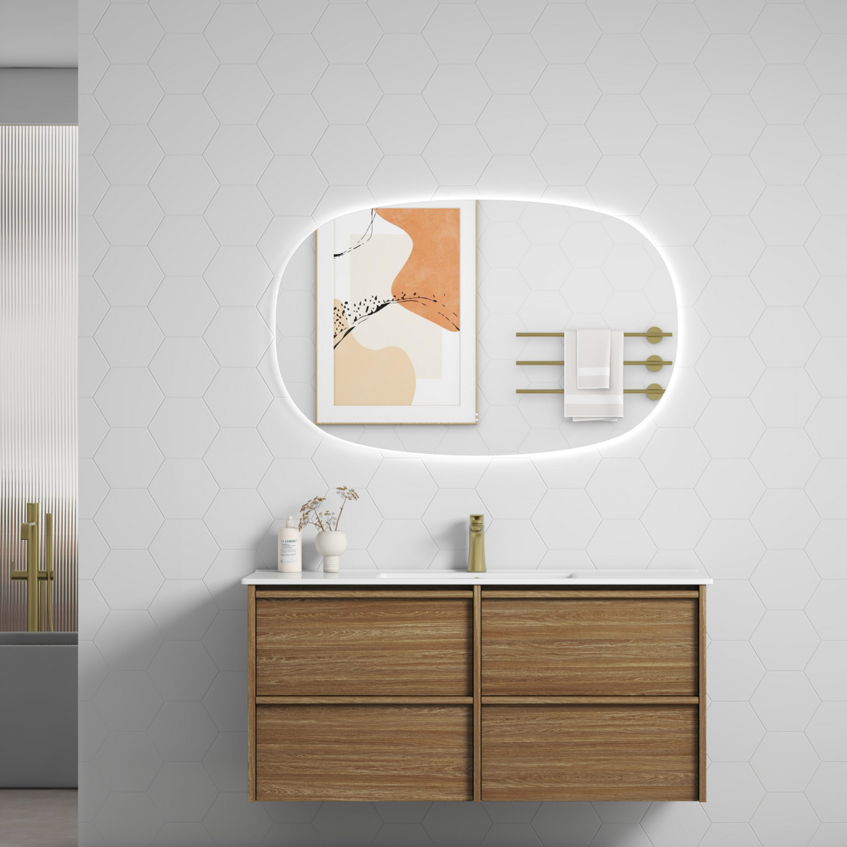 A modern floating bathroom vanity with a light oak wood finish and a white countertop, styled with a glowing oval backlit mirror, gold towel bars, and minimalist decor .